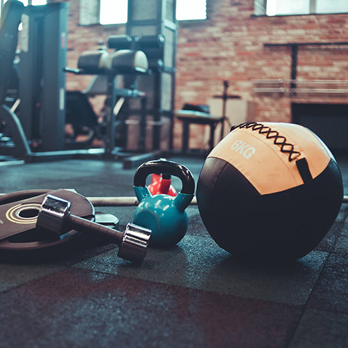 Medicine ball, dumbbell, kettlebell and other equipment on the gym floor